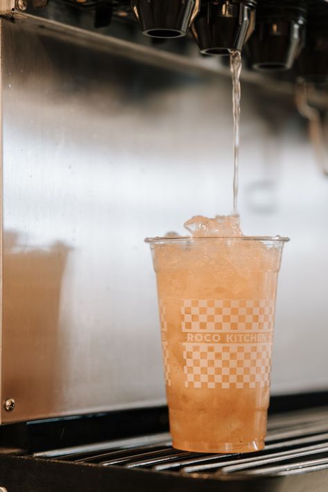 Ice machine dispensing into a clear plastic cup on a counter.