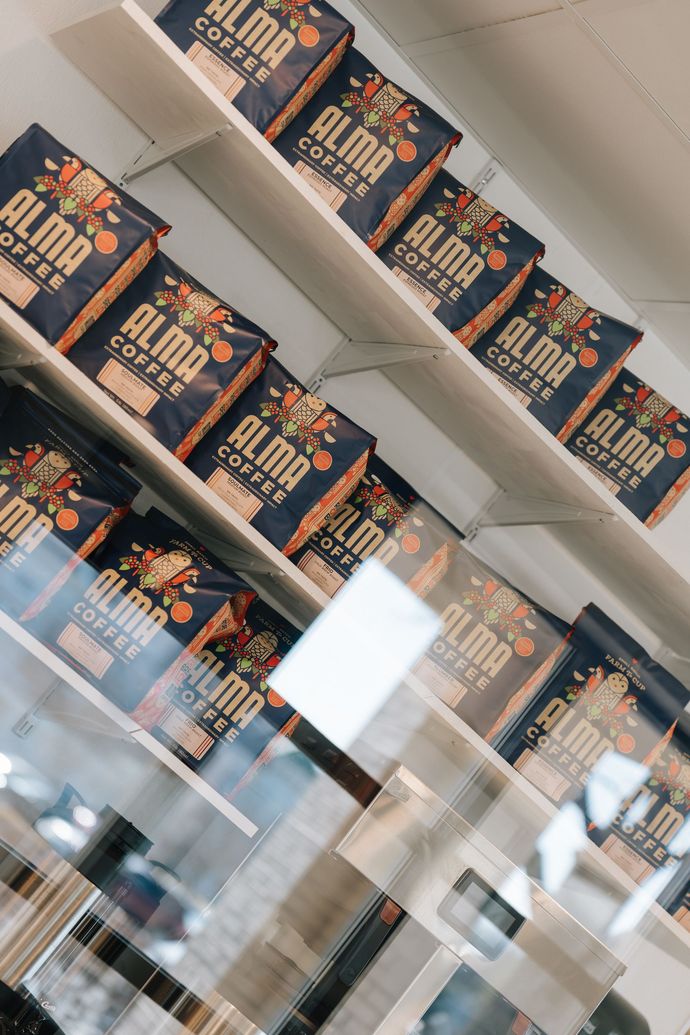 Rows of orange-and-black product boxes on shelves in a store display, seen through reflective glass