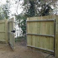 A wooden fence with a gate that is open.