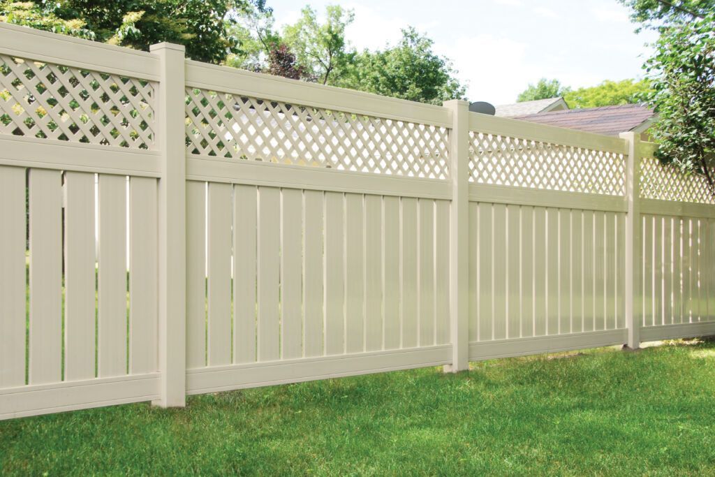 A white fence is sitting on top of a lush green lawn.