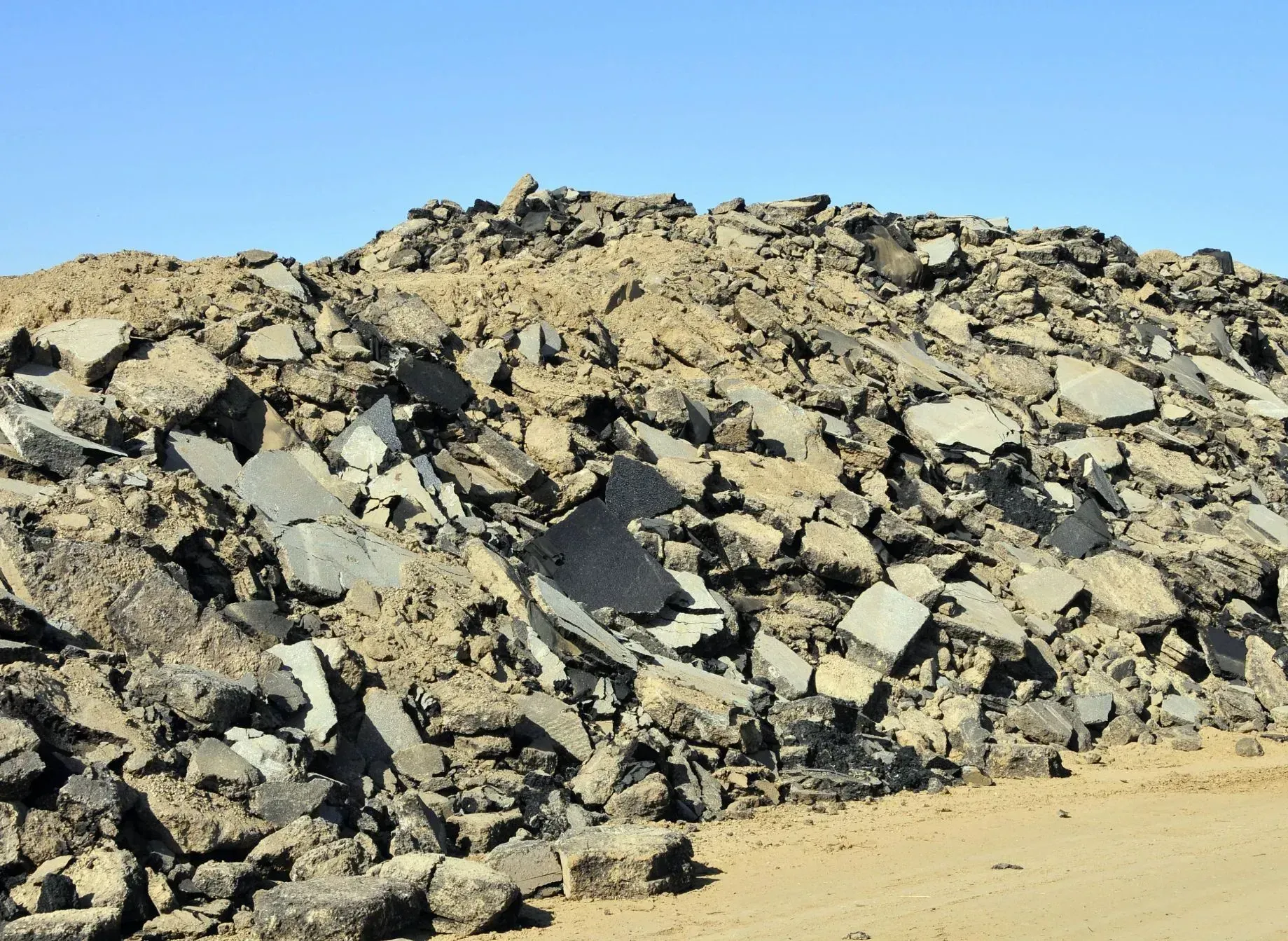 A pile of rocks in the desert with a blue sky in the background