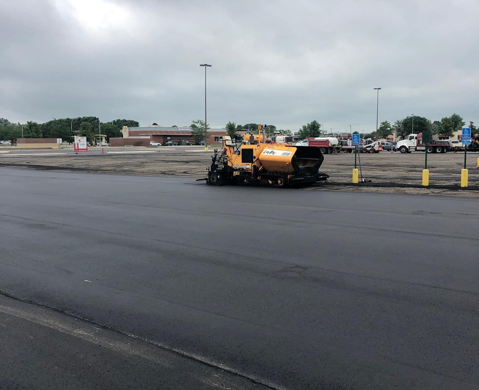 A yellow truck is sitting in the middle of a parking lot