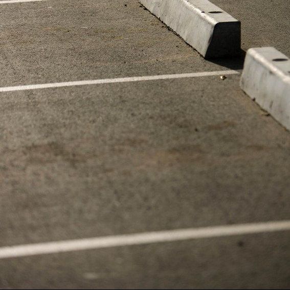 A parking lot with white lines and concrete curbs