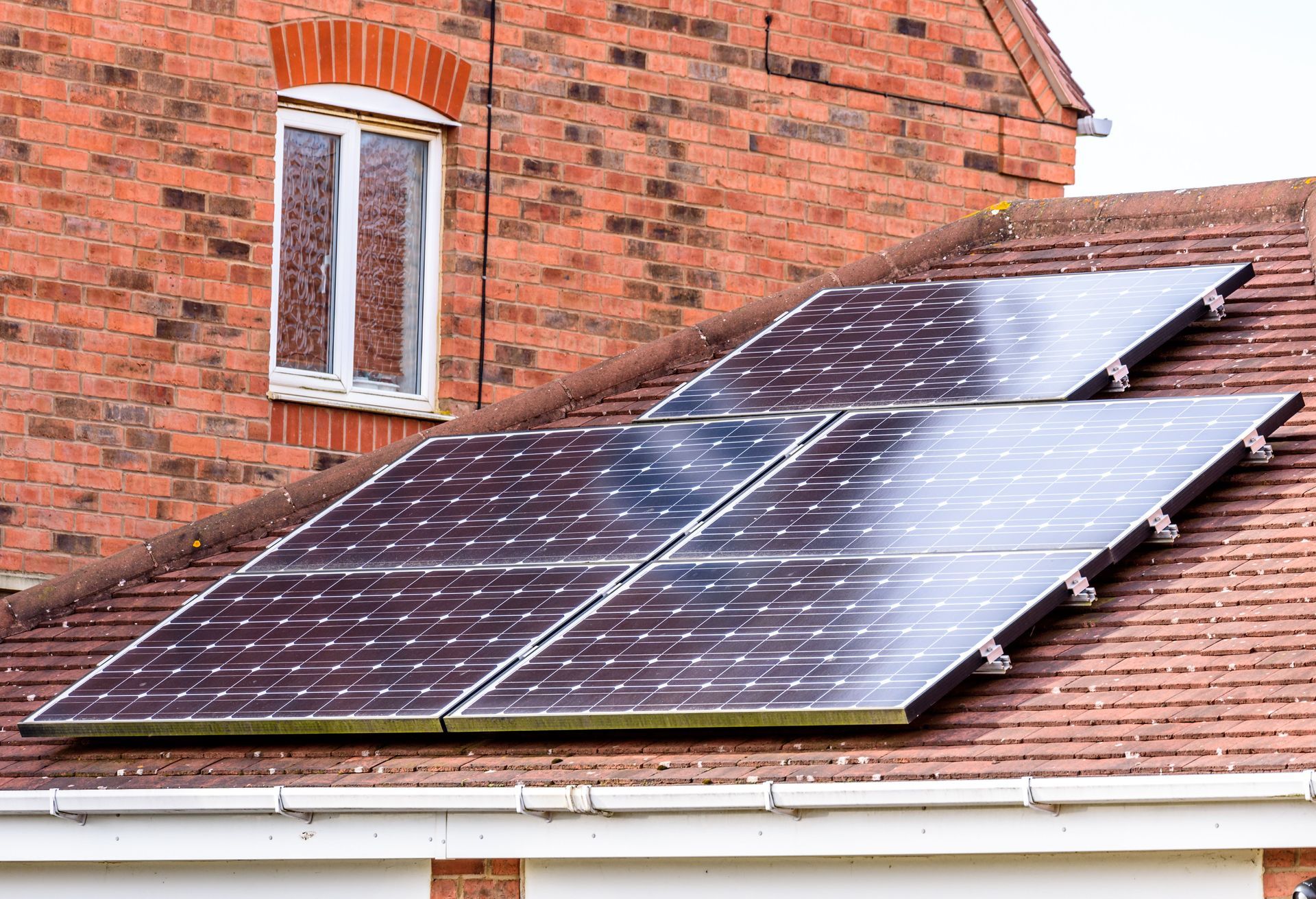 Solar panels installed on a red brick house roof