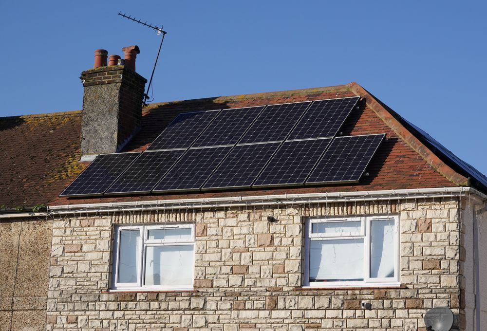 House roof with solar panels against a blue sky