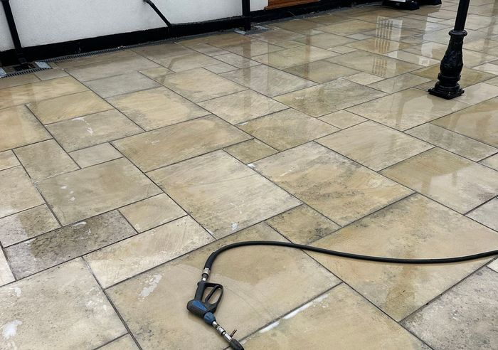 Black cable and plug on a beige tiled floor near a black post