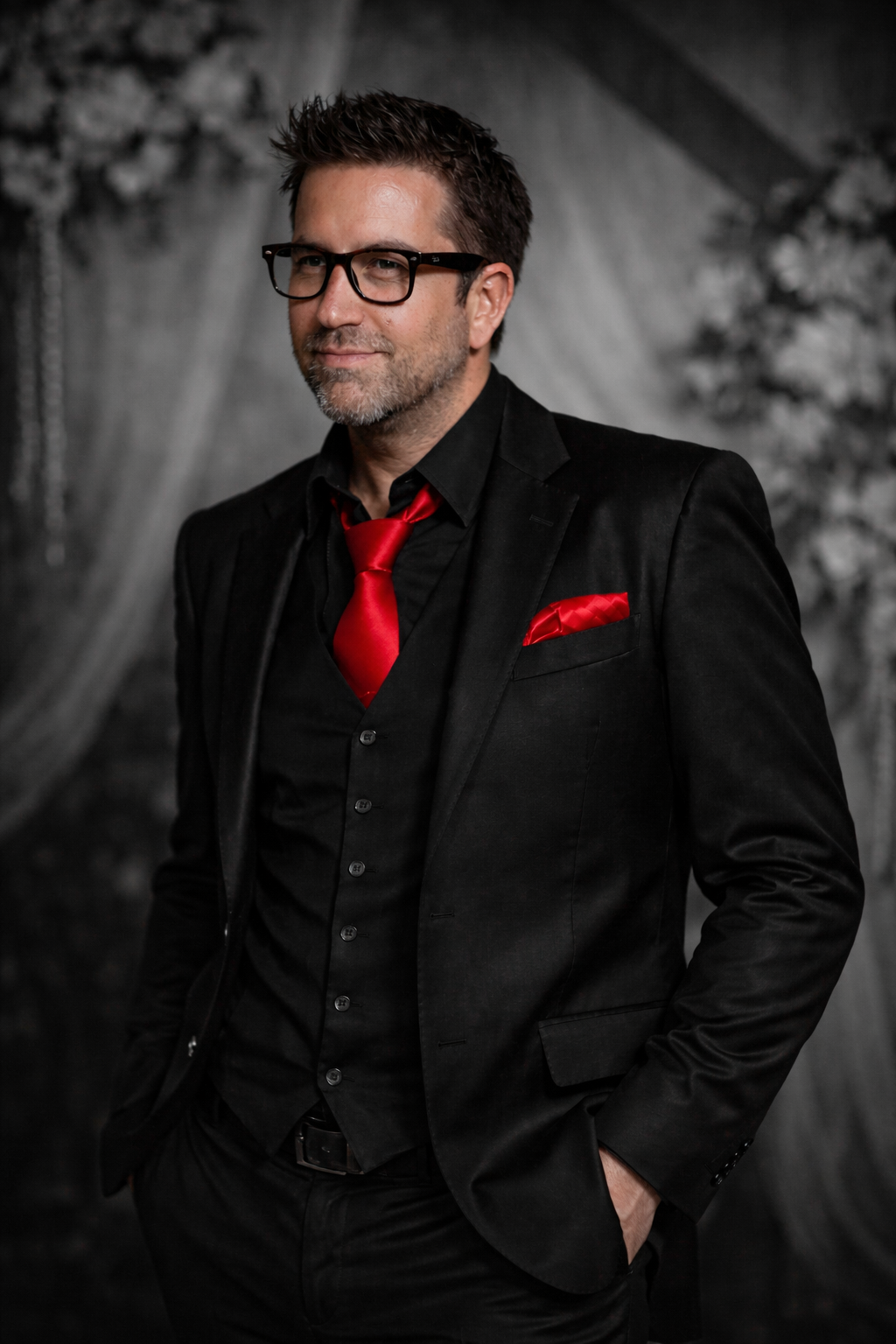 A man in a suit and tie is leaning against a brick wall.