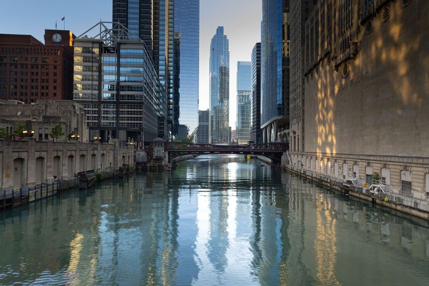 The Chicago River and downtown Chicago architecture beneath a clear blue sky.