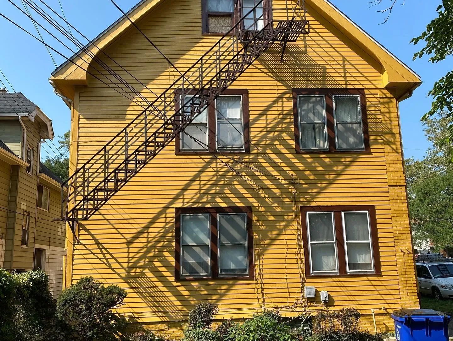 A yellow house with a fire escape on the side