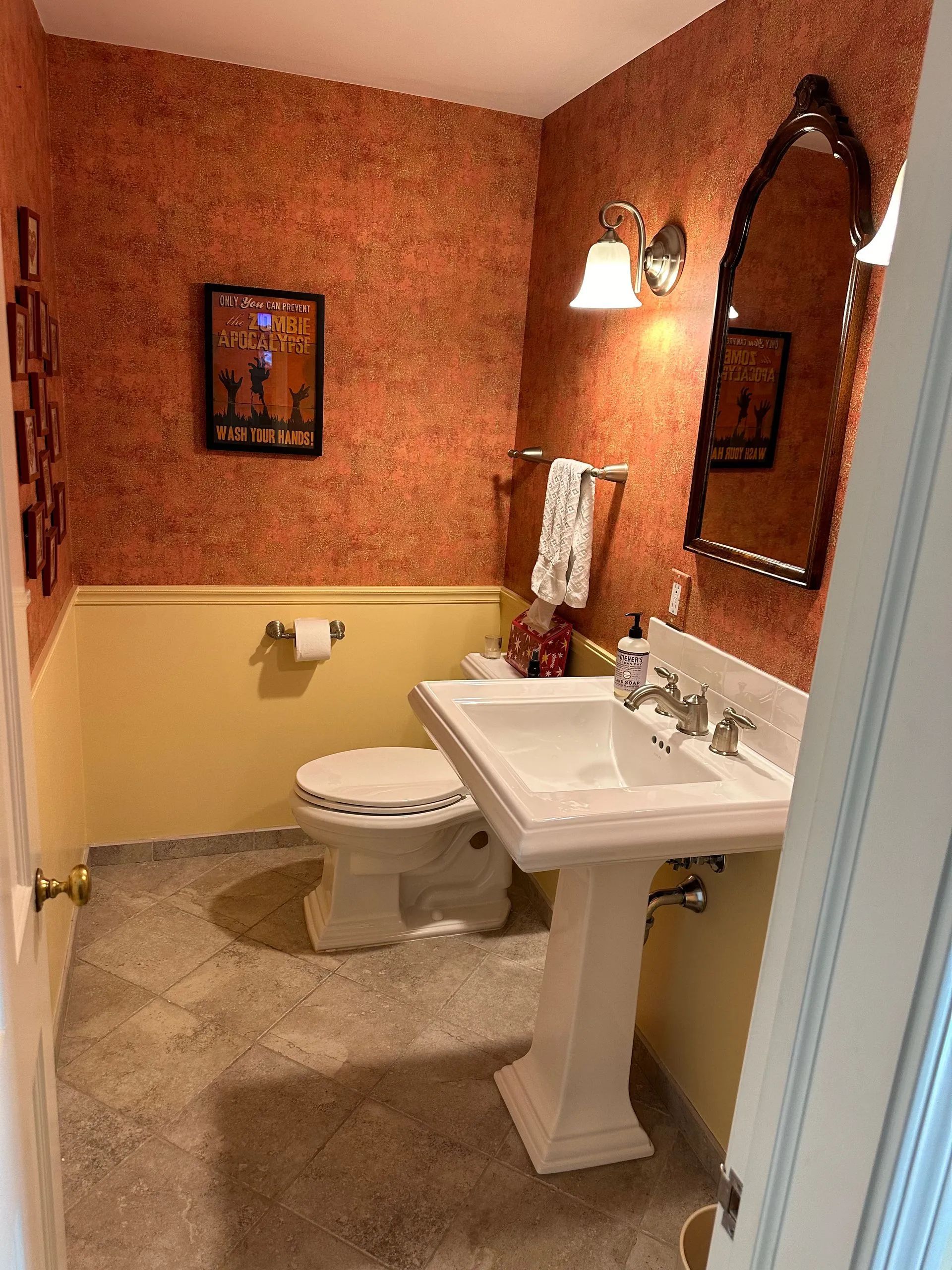 A bathroom with a toilet , sink and mirror.