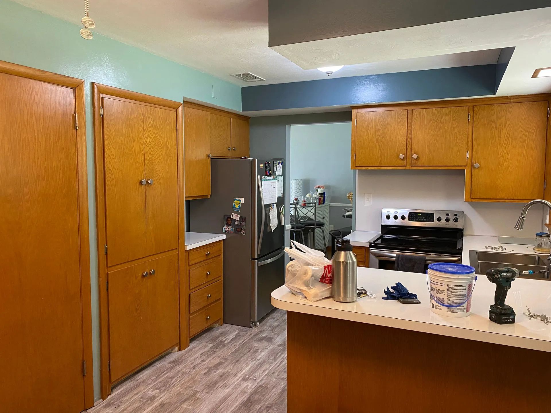 A kitchen with wooden cabinets , a refrigerator , a stove , and a sink.
