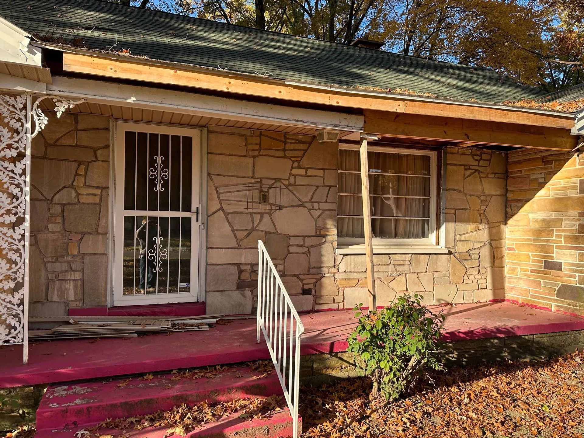 A small stone house with a porch and stairs.