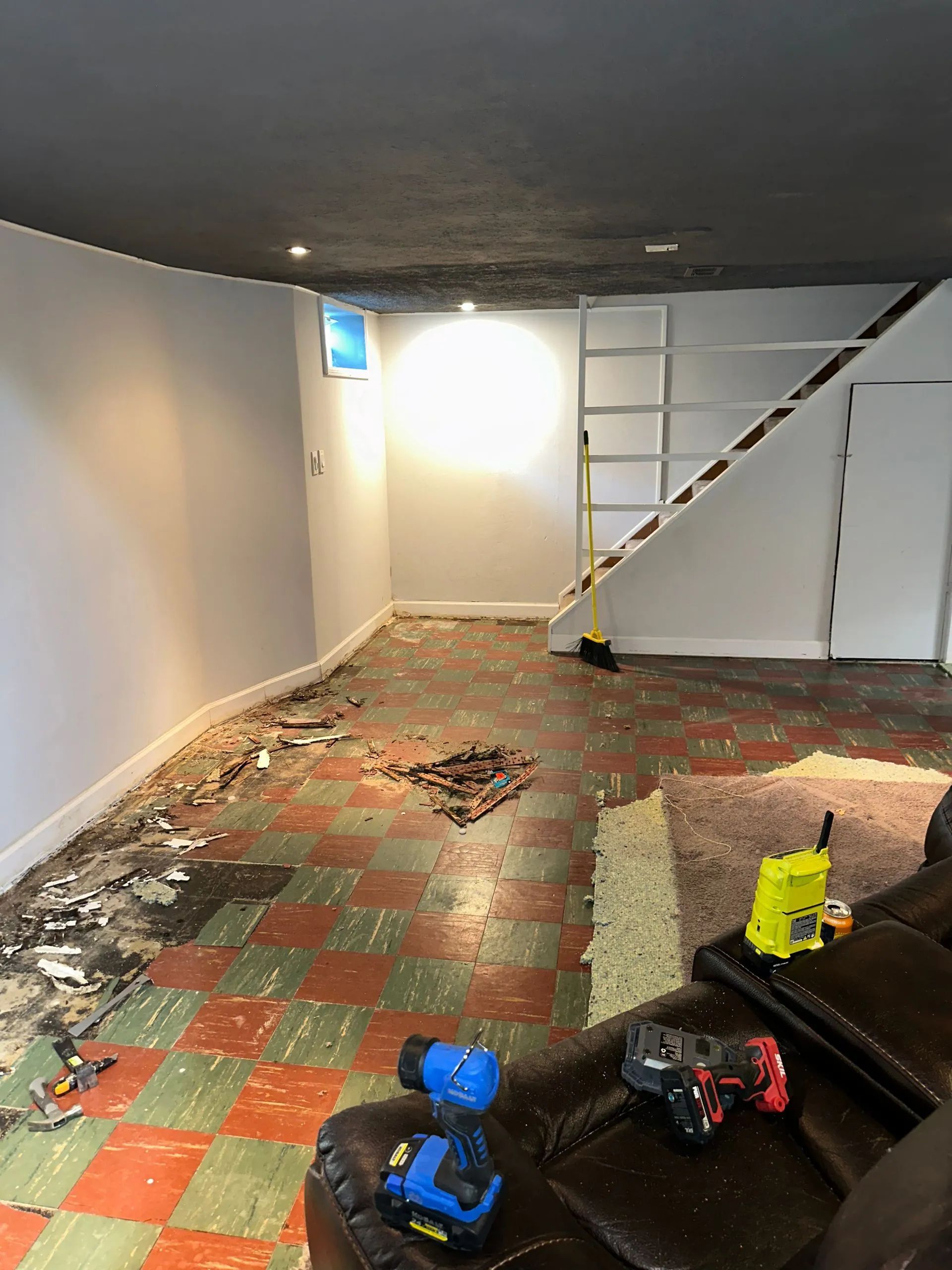 A living room with a checkered floor and a staircase.