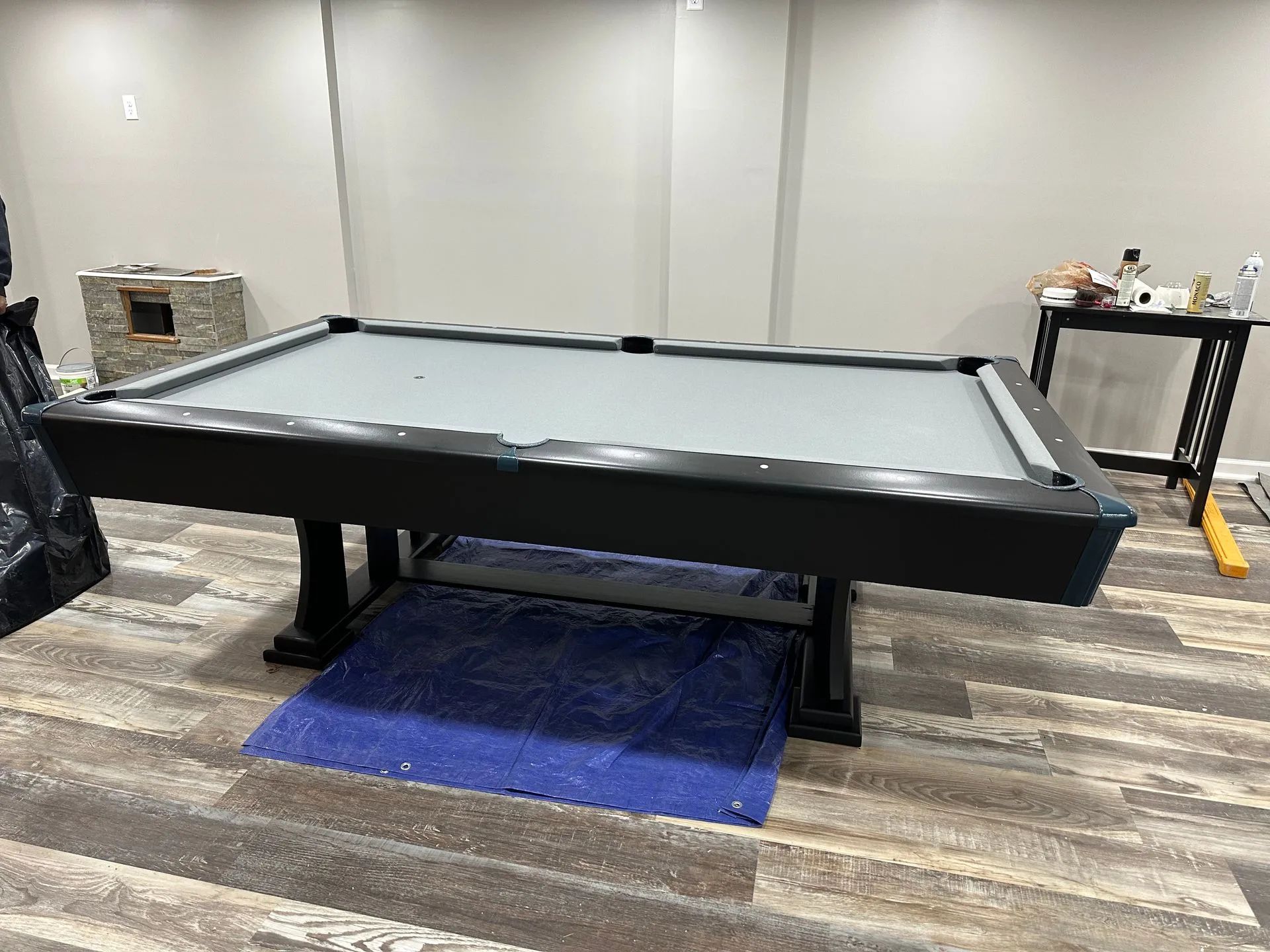 A pool table is sitting on a wooden floor in a room.