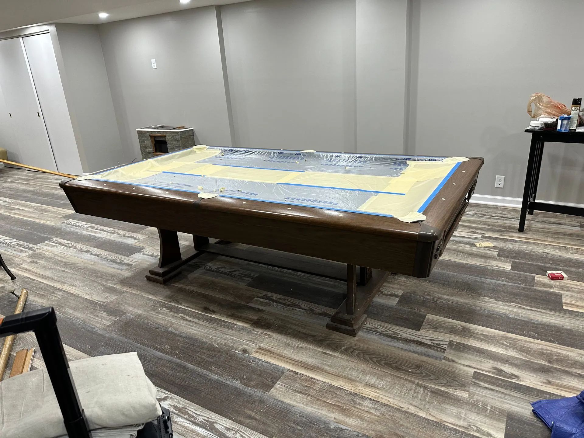 A pool table is sitting in a room with a wooden floor.