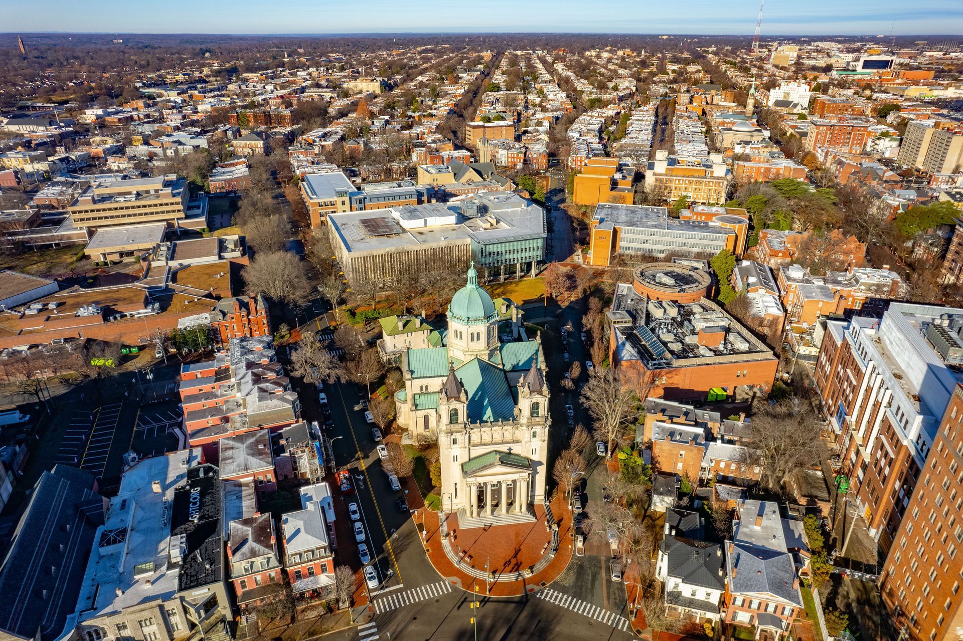 Aerial view of the Cathedral of St. Matthew the Apostle with a teal dome, surrounded by urban buildings in Washington, D.C.