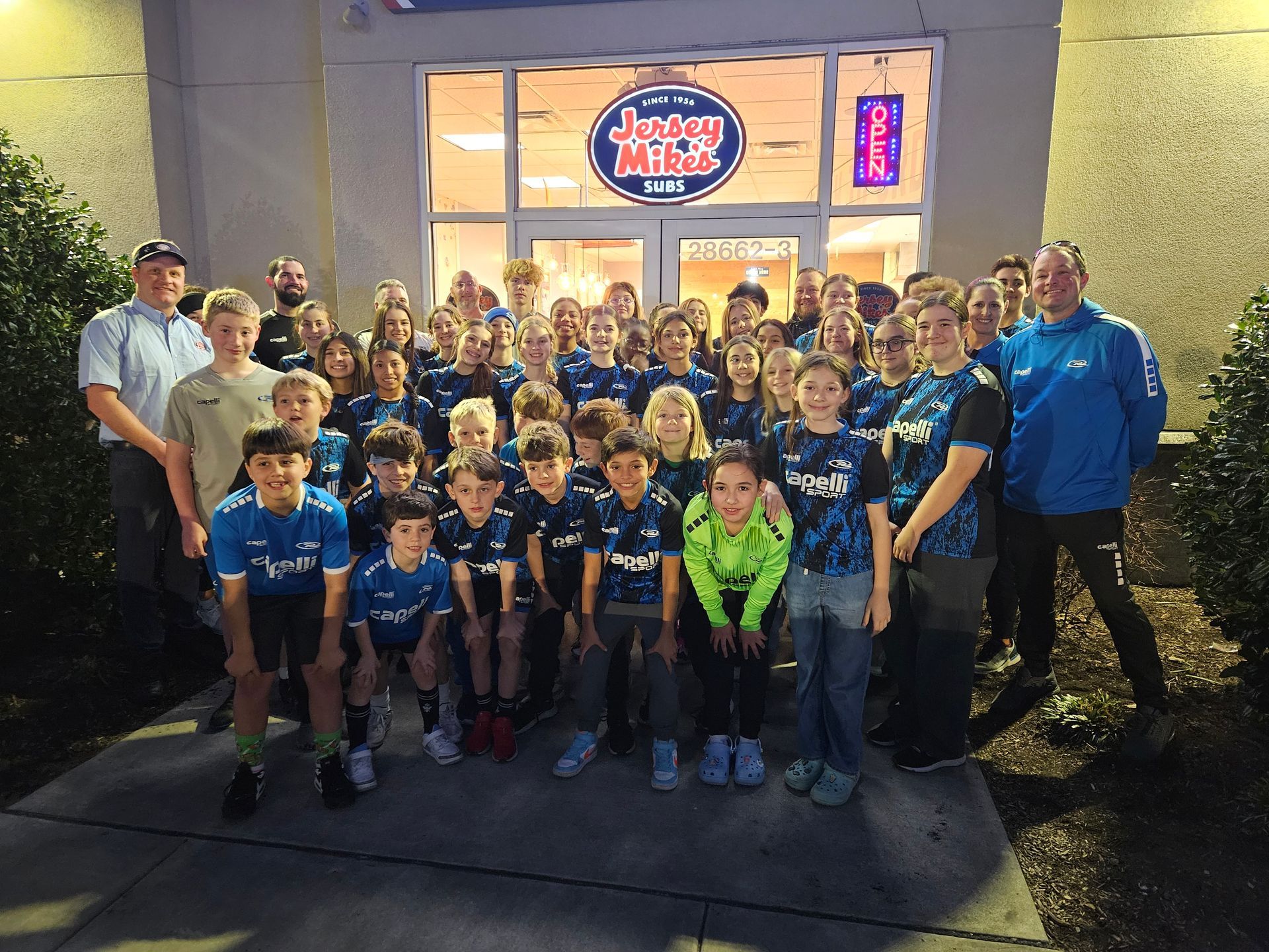 A group of people posing for a picture in front of a dairy queen restaurant