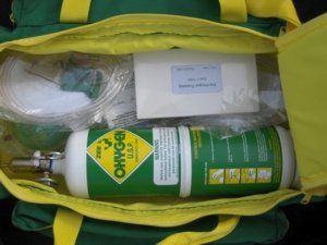 Green and yellow medical kit open, oxygen tank inside.