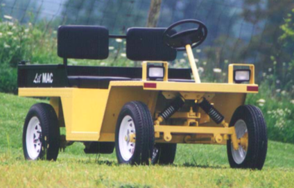 Yellow Lil Mac utility vehicle with black seating on green grass.