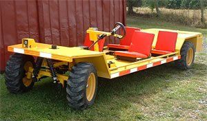 Yellow, open-air utility vehicle with four seats; off-road tires, red seats, black steering wheel.