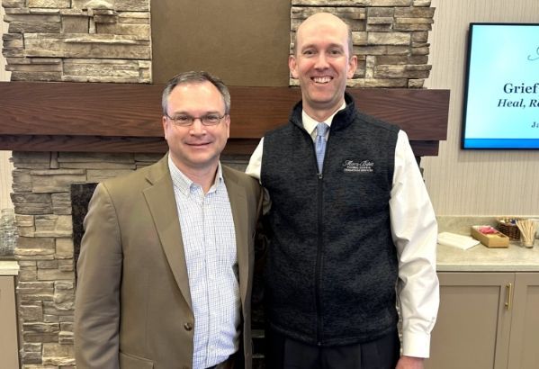 two men are posing for a picture in front of a fireplace. Morris-Baker Funeral Home & Cremation Services