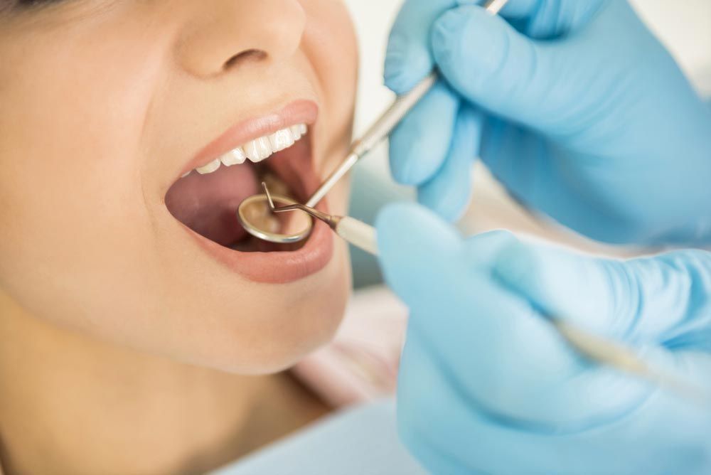 A Woman is Getting Her Teeth Examined by a Dentist — Advanced Dental Southern Highlands in Moss Vale, NSW