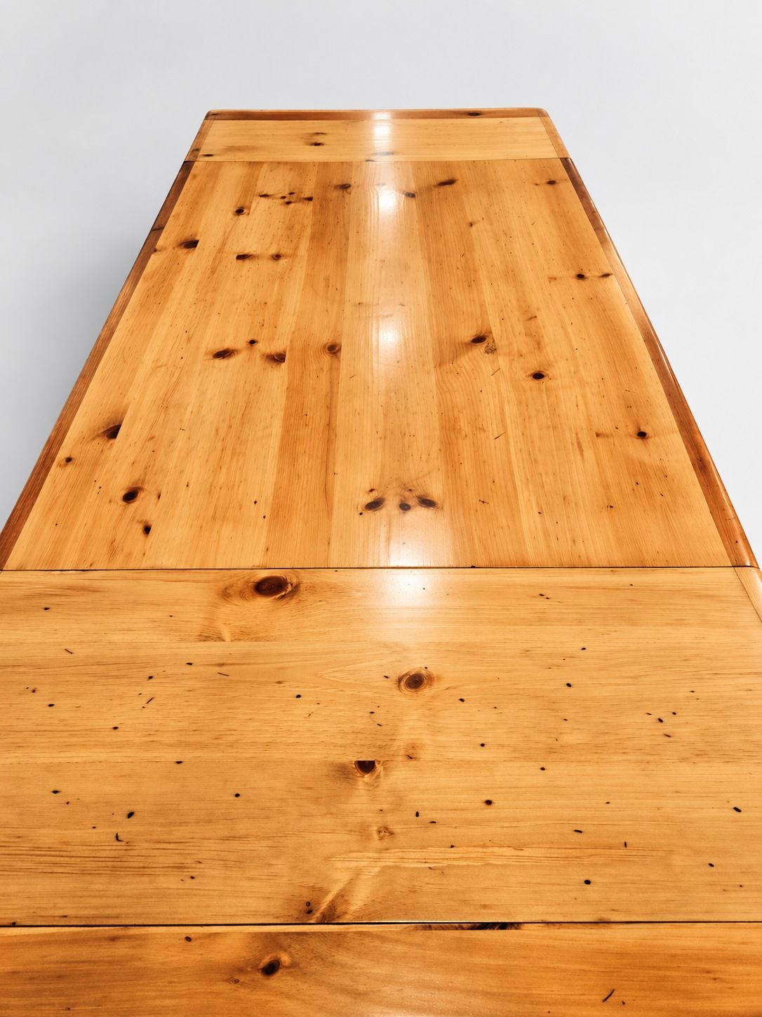 Close-up of a light wooden table surface with visible grain and knot marks