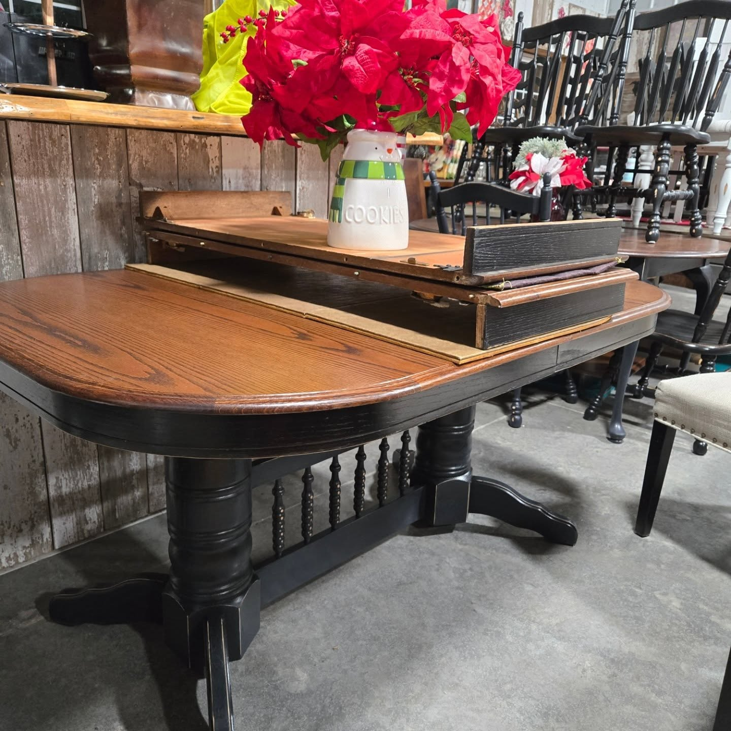 Wooden dining table with a tray and red flowers in a rustic furniture shop
