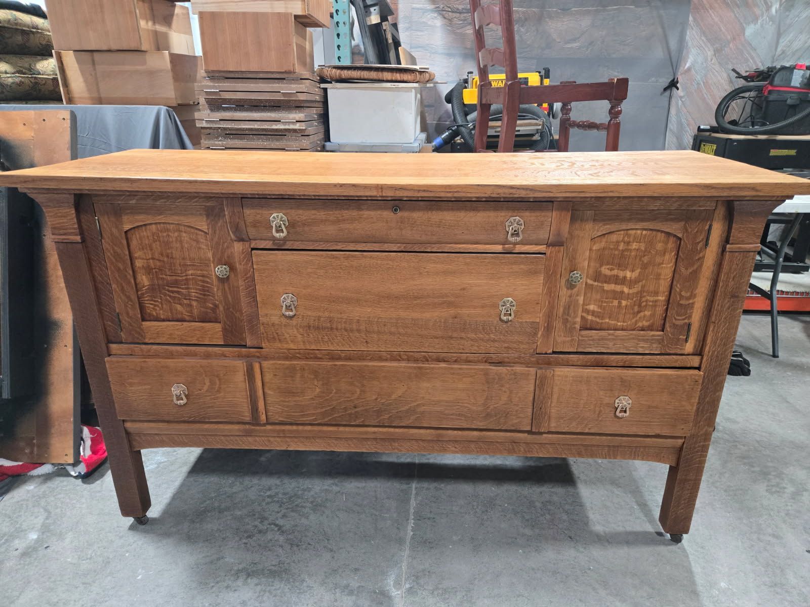 Rustic wooden sideboard with drawers and cabinet doors in a workshop setting