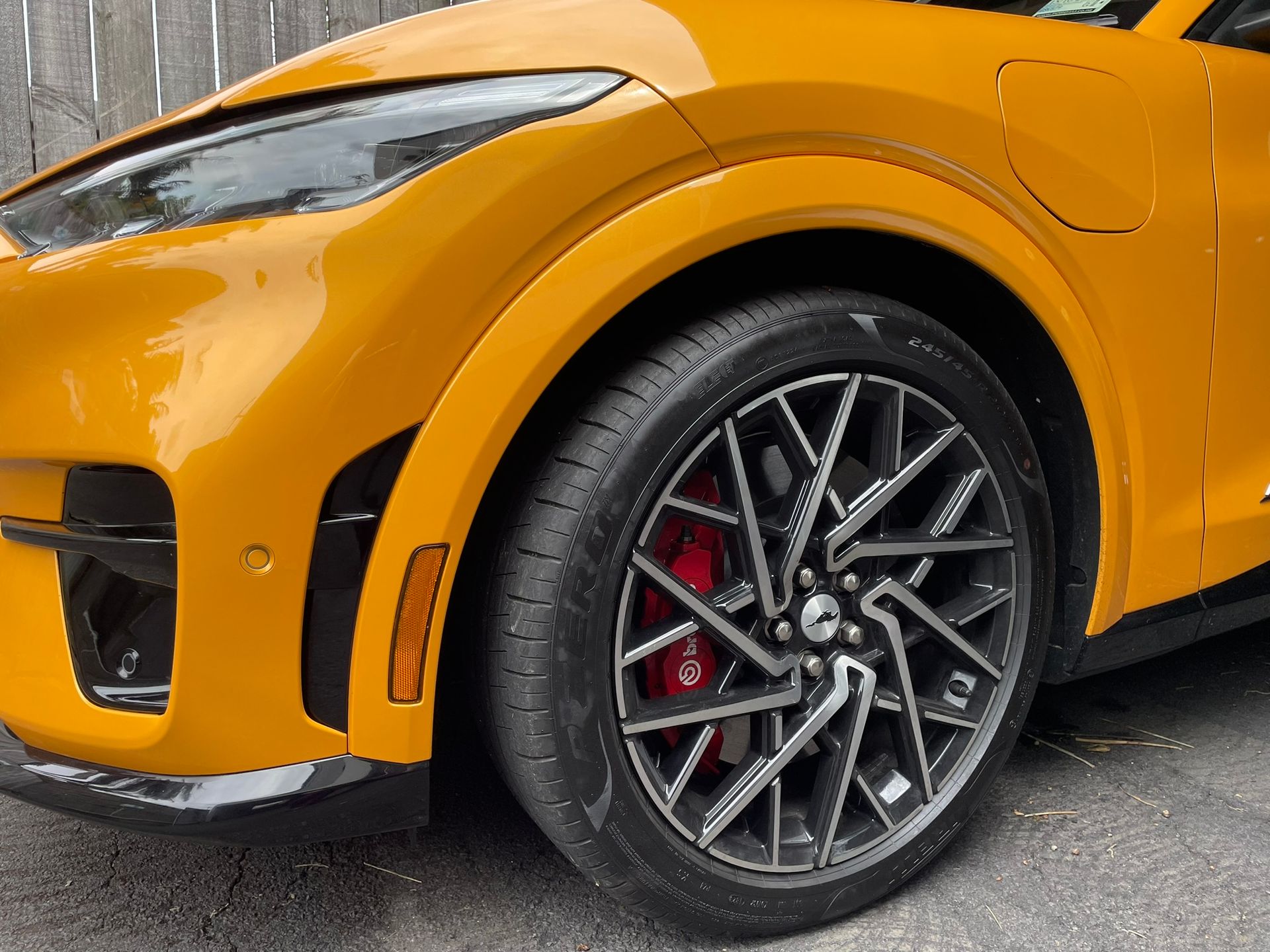 Close up of orange Mustang with distinctive wheel pattern.