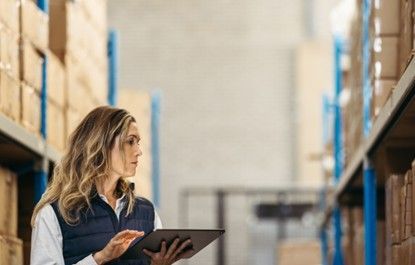 Logistics worker using a tablet to count warehouse stock