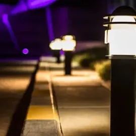 Dimly lit sidewalk with glowing black lanterns and purple lights in the background.