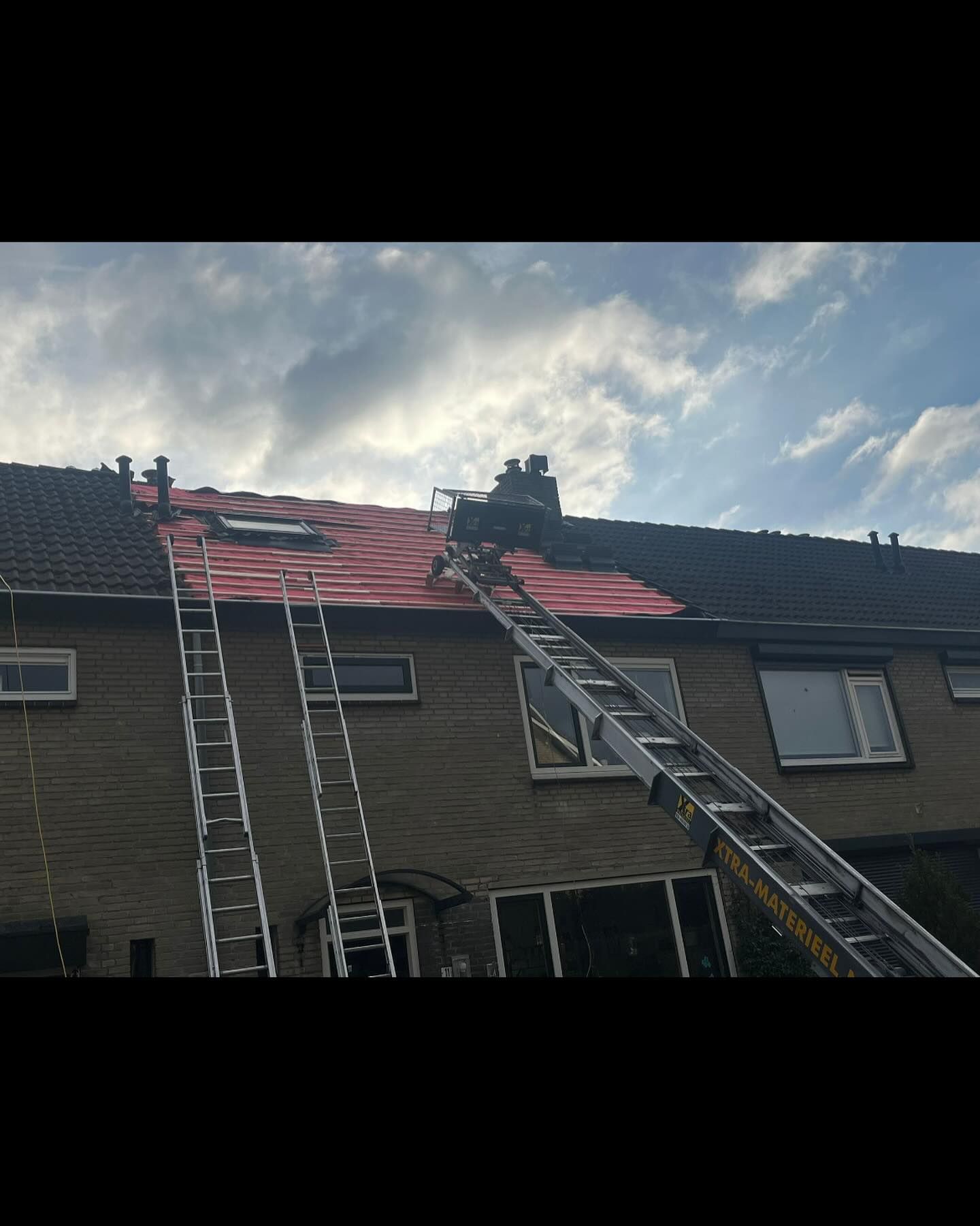 een groep mensen werkt op het dak van een huis.