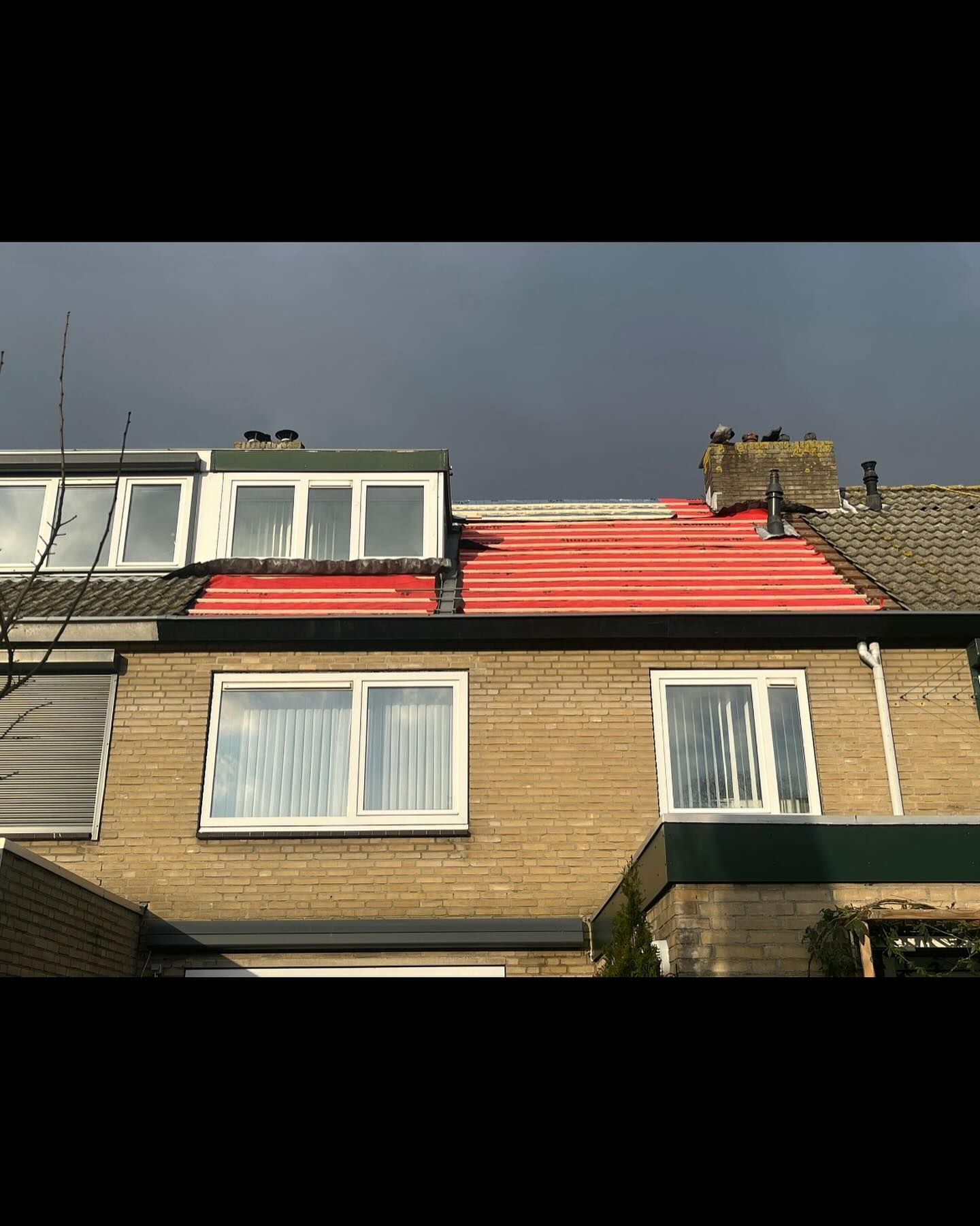 het dak van een huis wordt rood geverfd.