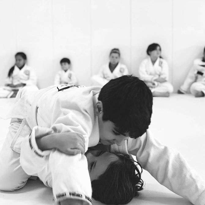 A man is teaching a woman kickboxing.