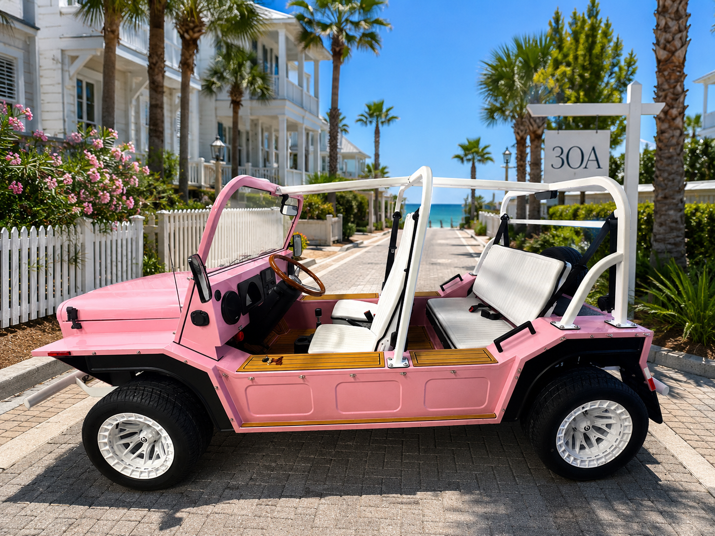 Pink moke golf cart parked on a sunny street near white buildings and palm trees by the sea