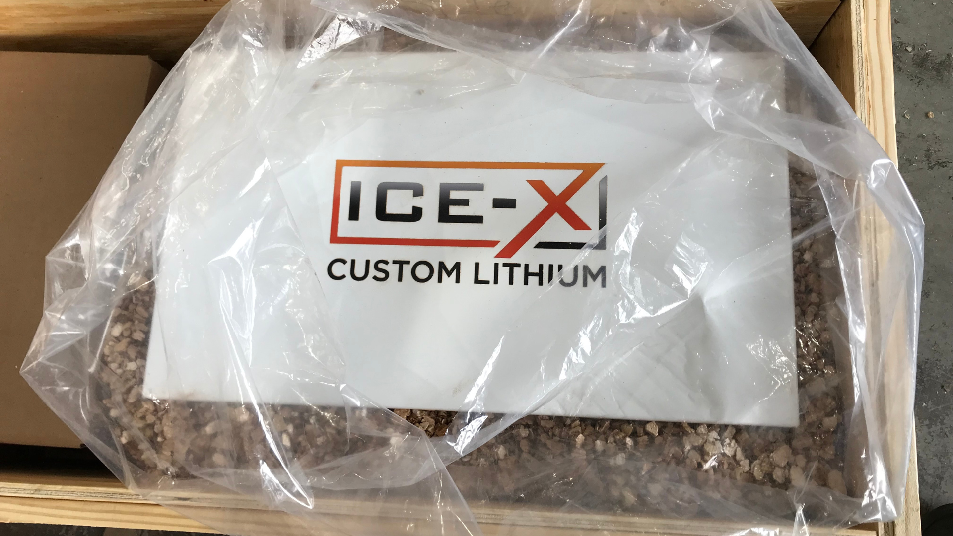 An ice-x custom lithium battery is sitting in a wooden box.