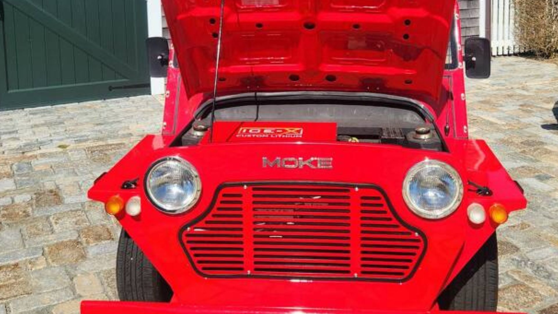 Red Mini Moke with hood open, showing engine and