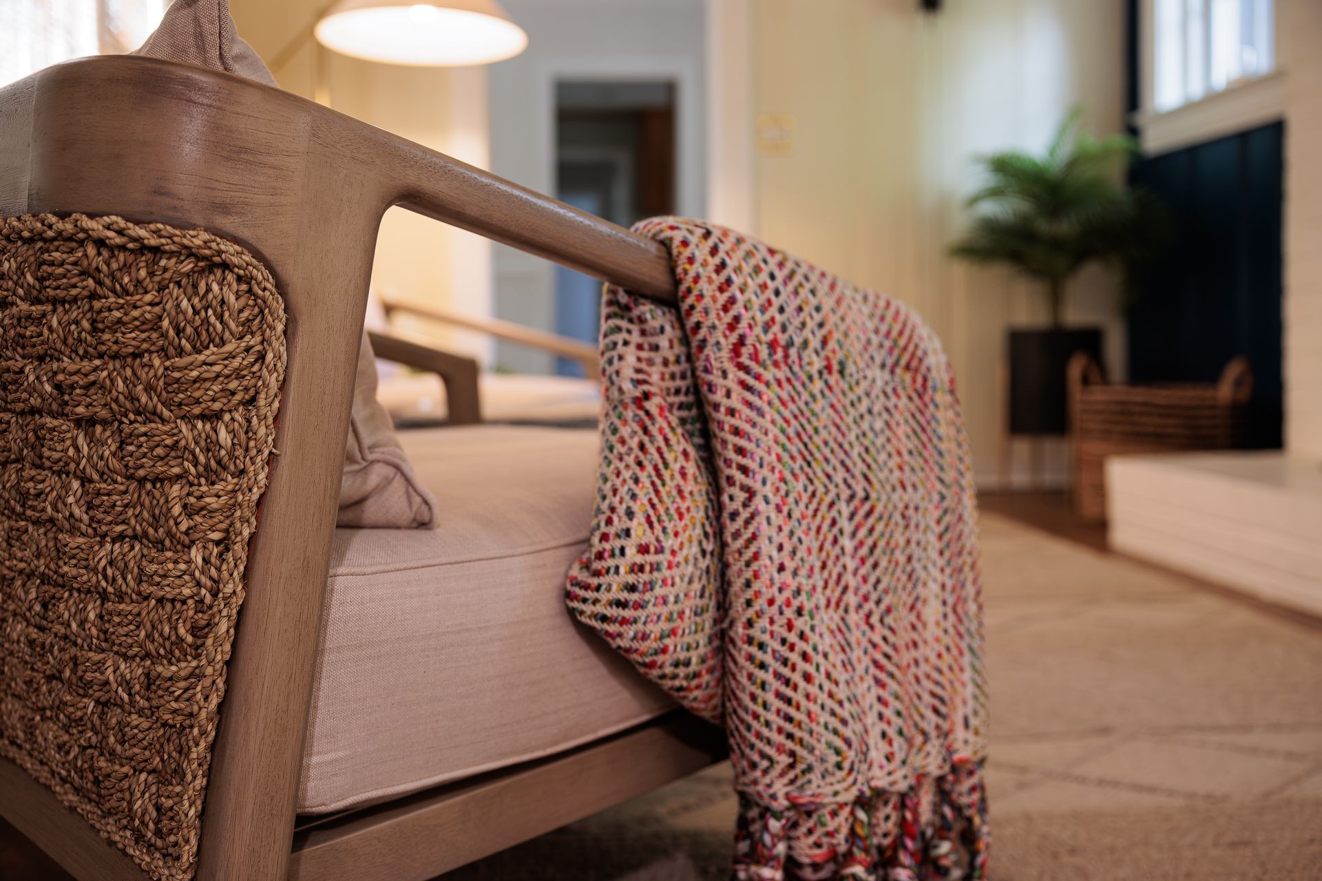 Upholstered chair detail with patterned throw in a warm living space