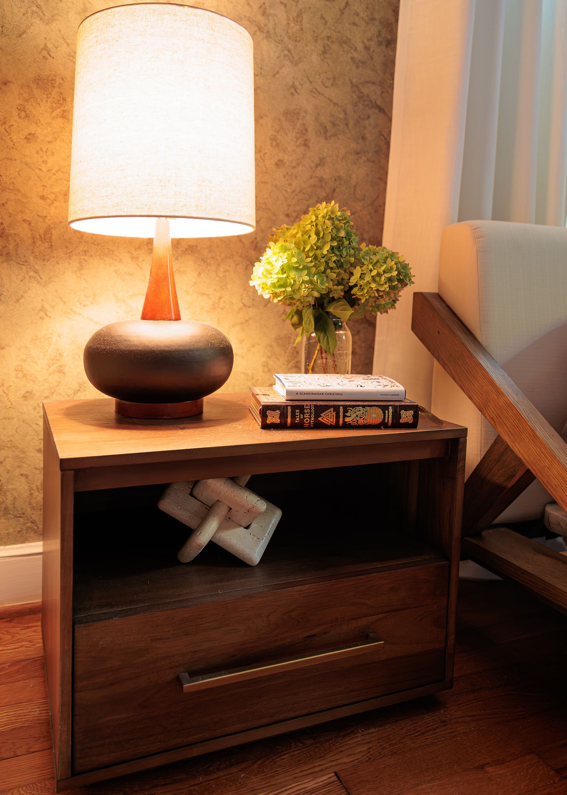 Bedside lamp and floral arrangement against textured wallpaper