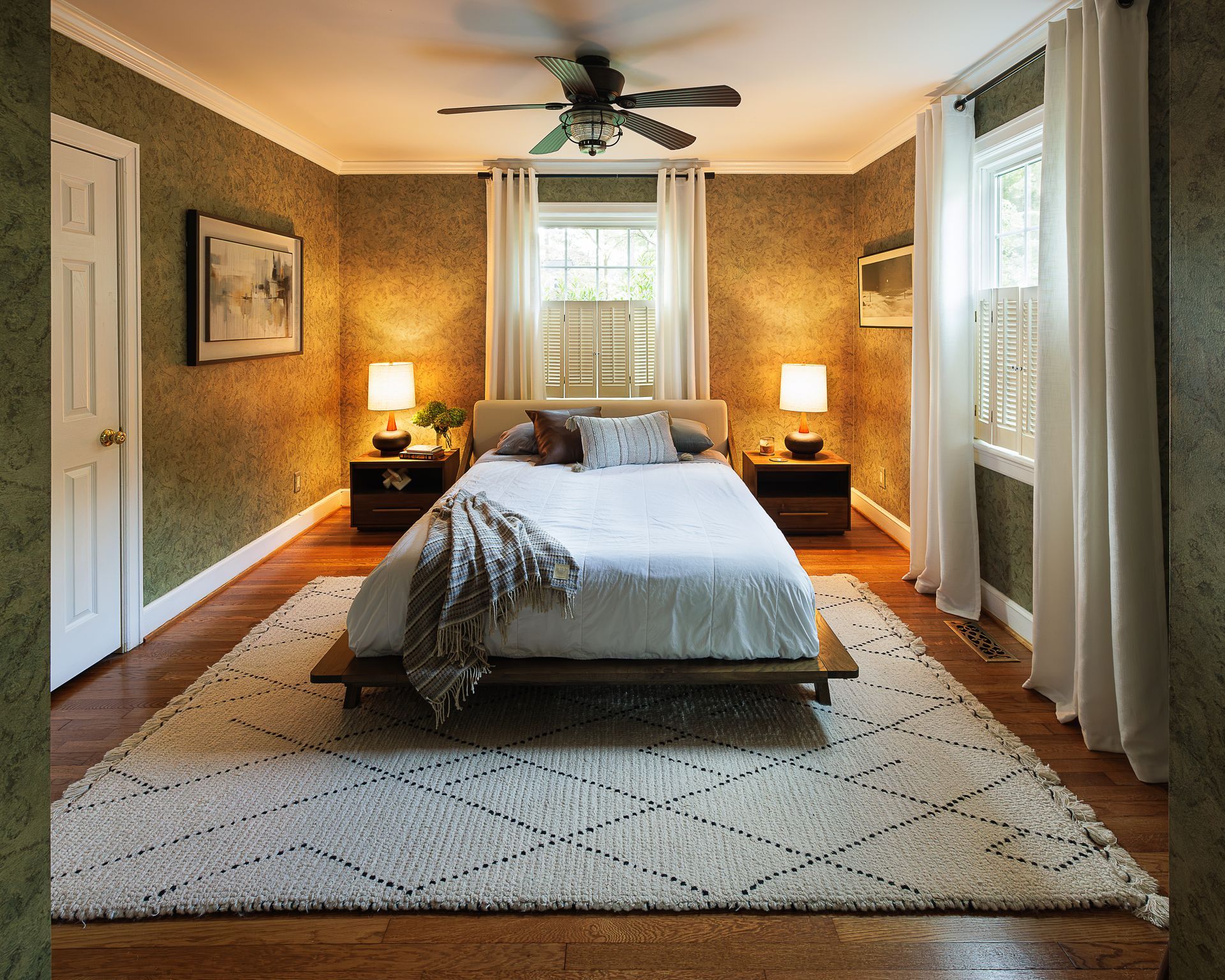 Cozy bedroom with patterned wallpaper, platform bed, and warm bedside lighting