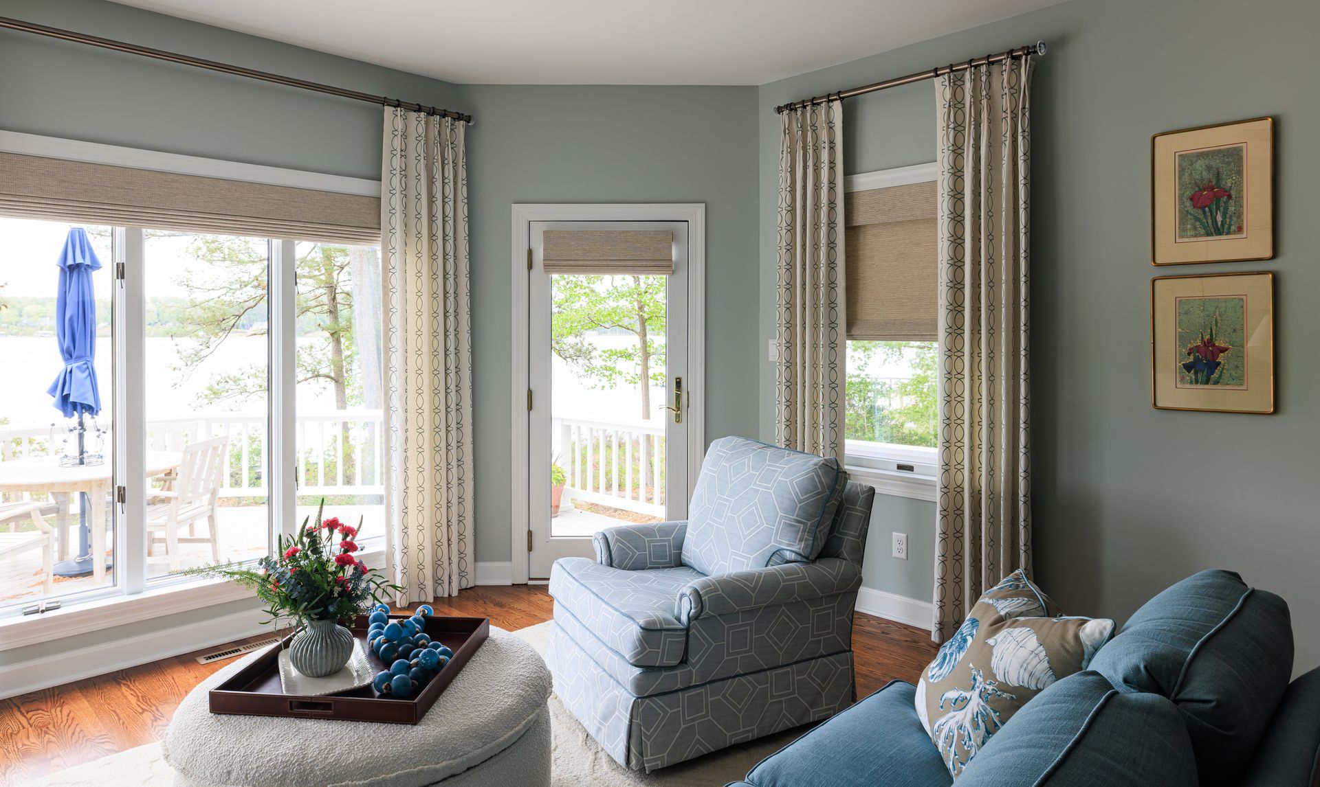 Cozy sitting room with upholstered chairs, custom drapery, Roman shades, and natural light