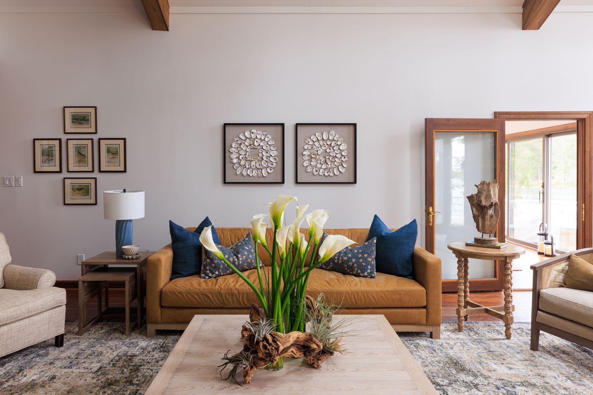 Warm transitional living room with stone fireplace, wood beams, and layered seating