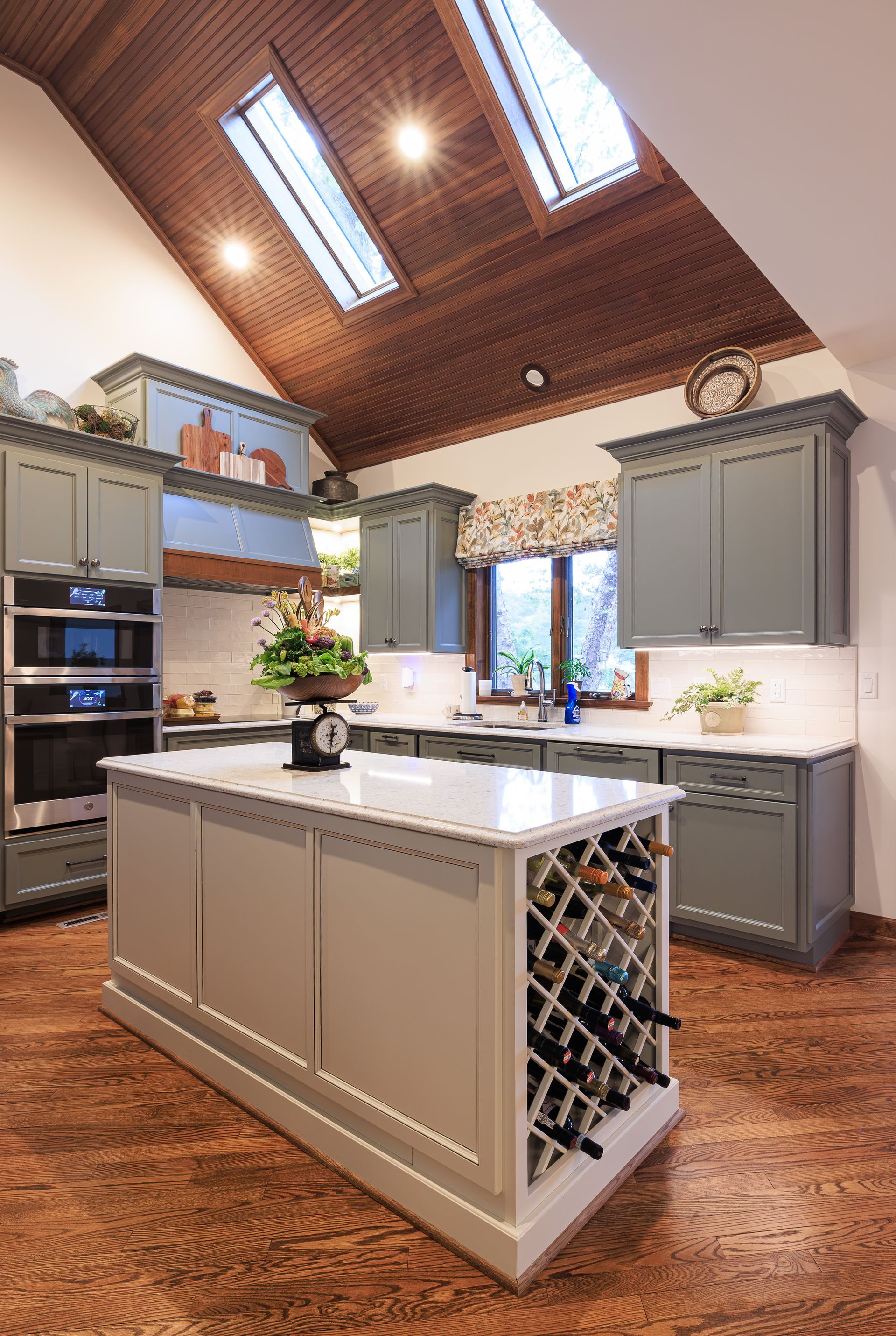 Custom kitchen with painted cabinetry, natural wood accents, and recesed lighting