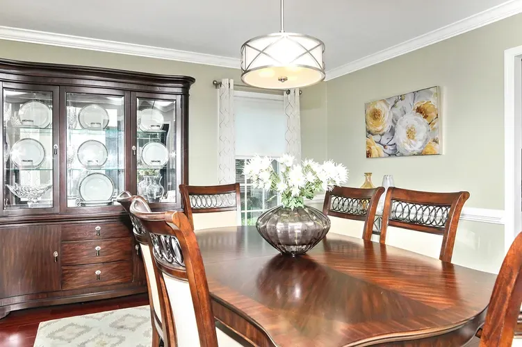 Dining room with traditional wood furniture, display cabinet, and modern ceiling light