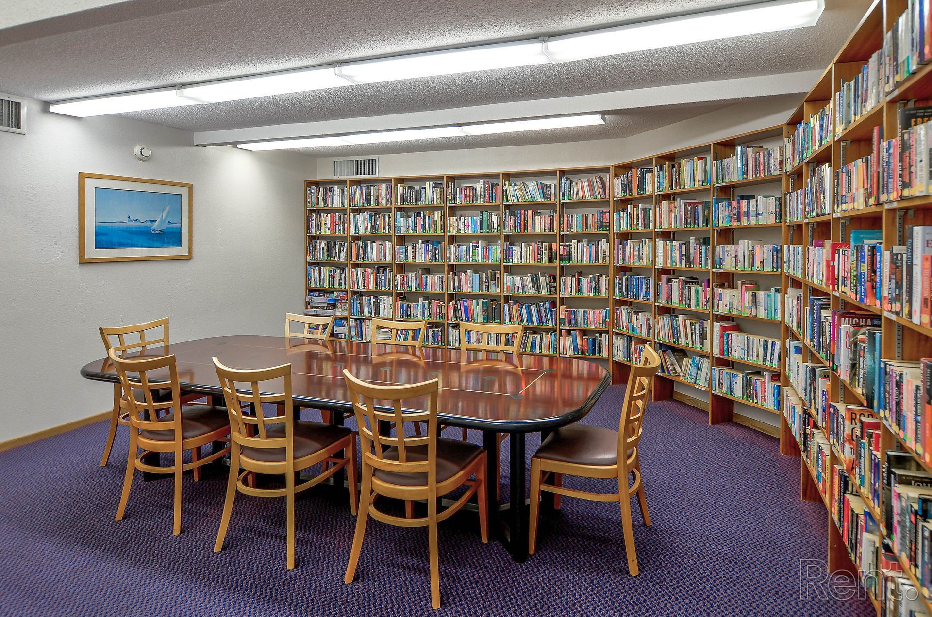 a library with a table and chairs surrounded by bookshelves