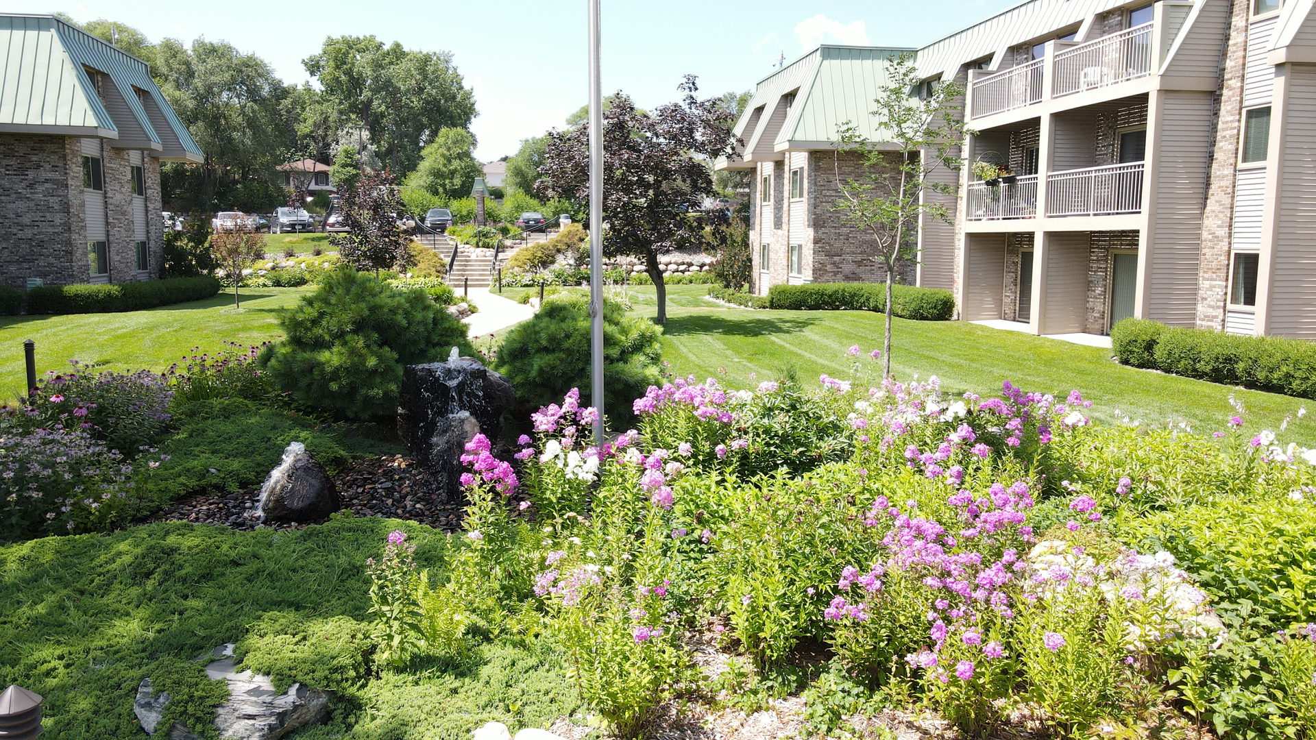 a garden with flowers and a fountain in front of a building .