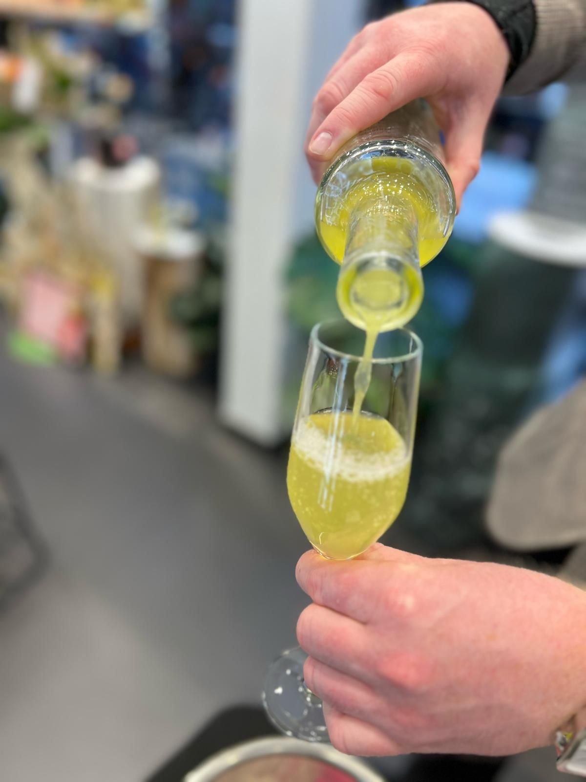 A person is pouring Aperitivo Pentone Lemon into a glass of Prosecco 