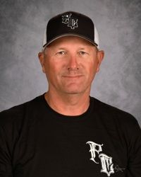 Portrait of a man in a black cap and T-shirt against a gray studio backdrop