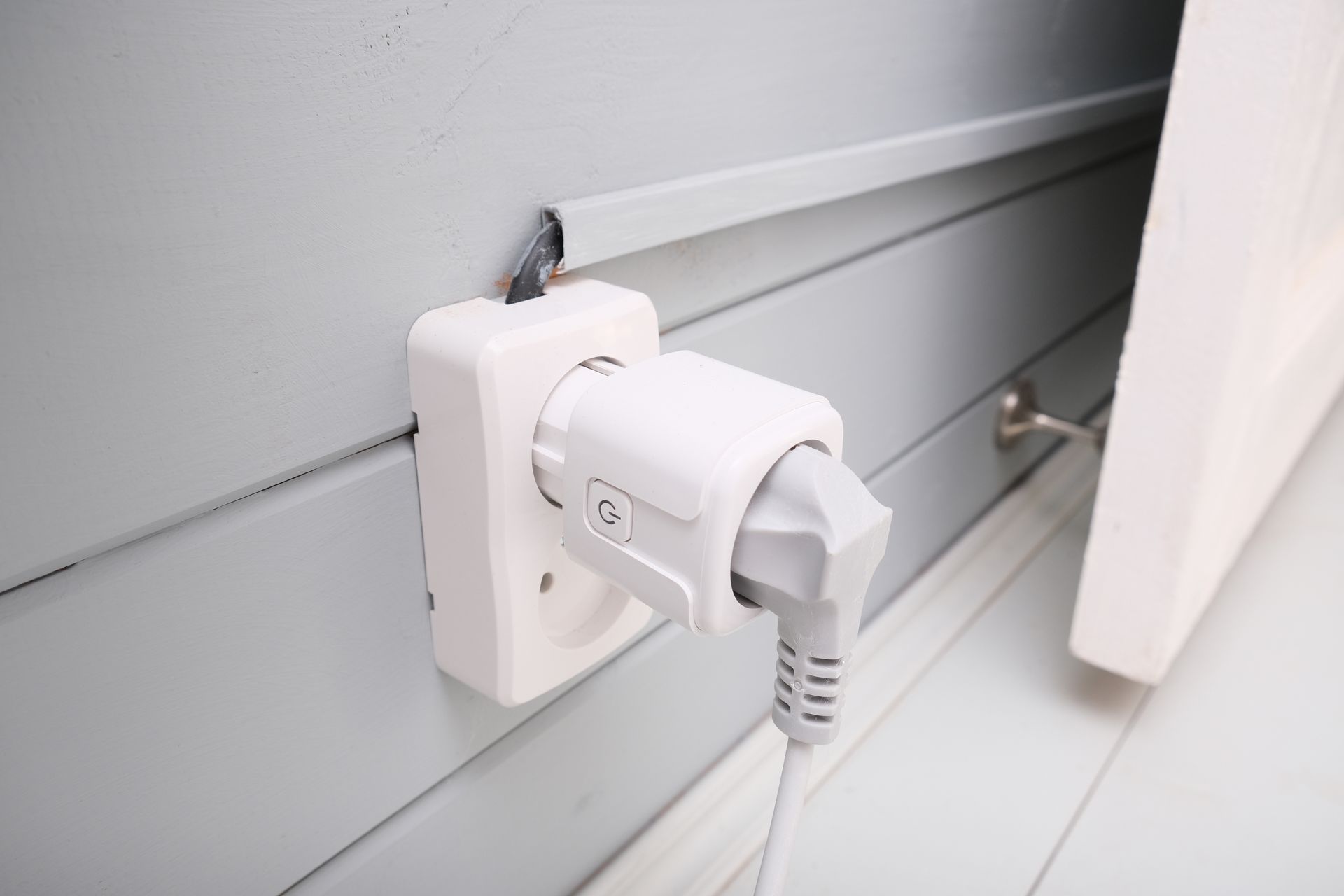 Electrician configuring a smart home device on a wall